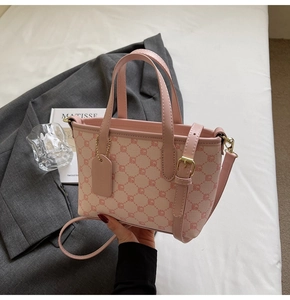 Vue détaillée du sac seau en toile monogramme rose avec poignée en cuir et boucles dorées