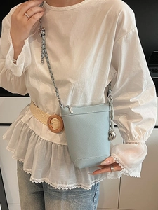 Petit sac seau bleu clair en cuir litchi avec bandoulière chaîne et pendentif boule argent