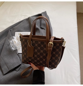 Vue détaillée du sac seau vintage marron avec finitions dorées et étiquette logo
