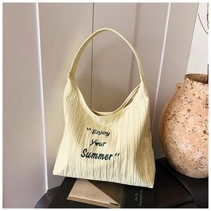 Détail du sac cabas jaune avec broderie Enjoy Your Summer dans un décor intérieur doux