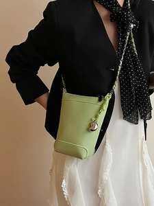Sac à bandoulière vert sauge pour téléphone avec chaîne et breloque cœur sur mannequin