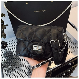 Close-up of black quilted crossbody bag with silver twist lock and chain strap detail