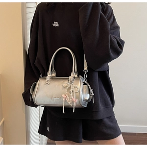 Borsa Boston metallizzata argento con ciondoli a perla e fiocchi indossata
