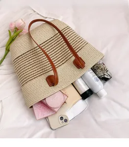 Dettaglio della capiente borsa shopper intrecciata con spazio per oggetti comuni