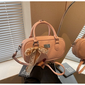 Borsa Boston rosa con trama coccodrillo e fiocco in pizzo delicato in vista ravvicinata