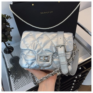 Close-up of silver quilted crossbody bag with metal twist lock and chain handle detail