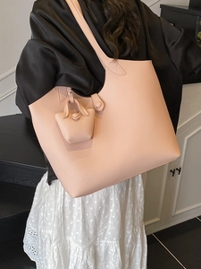 Pink large capacity faux leather tote bag shown on shoulder in minimalist interior