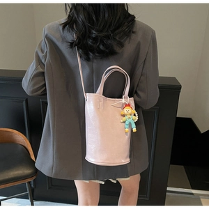 Detailed back view of pink PU leather bucket bag with a cute cartoon girl charm