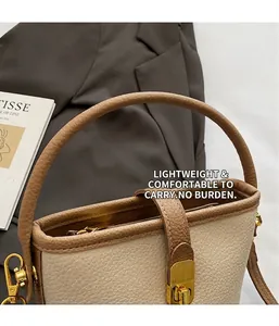 Détail du sac seau bicolore en cuir crème grainé avec boucle métallique dorée