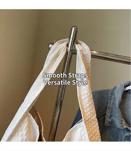 Detail of smooth white checkered tote bag strap with textured pleats on a hanger