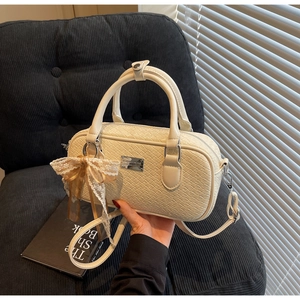 Dettaglio borsa Boston intrecciata crema con fiocco decorativo e finiture dorate