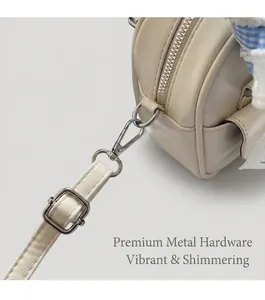 Detail of off-white leather bag with silver metal zipper, D-ring and adjustable strap