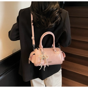 Dettaglio della borsa Boston in vernice rosa con fiocco di perle e ciondolo a cuore