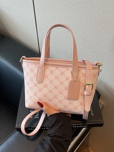 Sac à main rose avec motif monogramme, poignées en cuir et bandoulière réglable