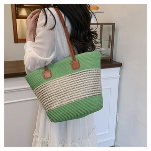 Dettaglio della borsa tote intrecciata verde con spalline in pelle marrone