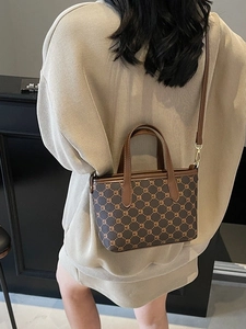 Sac seau vintage à motif géométrique marron avec anses en cuir porté par mannequin