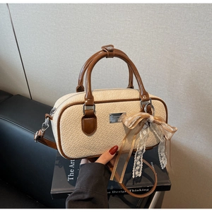 Dettaglio della borsa Boston in ecopelle testurizzata con logo in metallo e fiocco