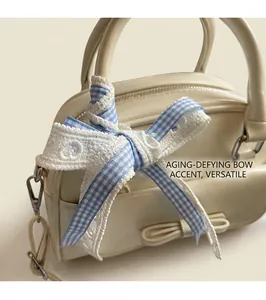 Detail of cream pillow bag featuring blue plaid and white lace bow decoration