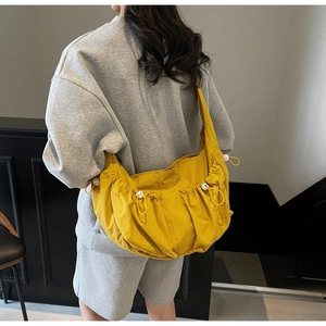 Detail of yellow dumpling bag showing the stylish drawstring pleats and storage capacity