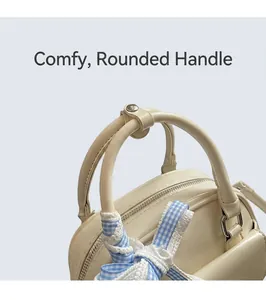 Detail of cream white Boston handbag with silk scarf against Matisse art book backdrop