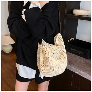 Close-up of cream crochet knit bag showing intricate hollow texture and slim black shoulder strap