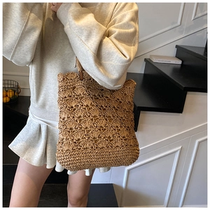 Detail of hand-woven straw shoulder bag with scalloped openwork pattern and soft lining