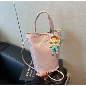 Detail of light pink leather bucket bag with FASHION logo and pearl doll charm