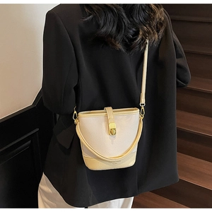 Sac seau bicolore tendance en cuir grainé, porté par un mannequin pour l'échelle de taille