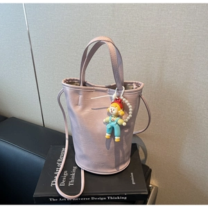 Detail of light purple PU bucket bag with FASHION text and pearl cartoon charm
