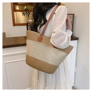 Dettaglio della borsa tote intrecciata a righe con spalline in pelle sulla modella