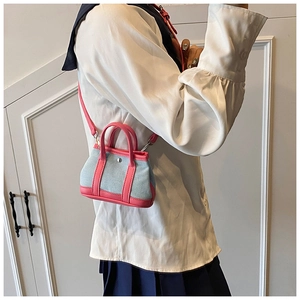 Close-up of mini blue denim and pink leather crossbody bag with silver hardware detail