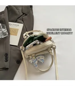 Detail of a beige Boston bag showing spacious interior with phone and lipstick storage