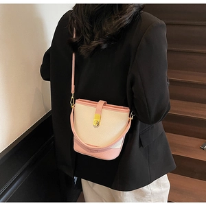 Détail du sac seau rose et beige avec texture lychee et fermoir pivotant doré