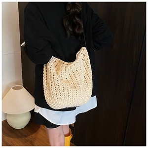 Detailed texture of beige crochet knit bucket bag with sleek dark shoulder strap