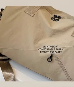 Detail of water-resistant nylon fabric with dual black zippers and sturdy woven strap