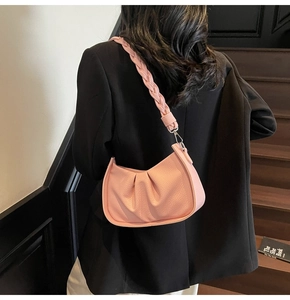 Detail of pink pleated leather crescent bag with a chunky braided shoulder strap