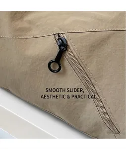 Macro view of khaki nylon bag featuring a smooth black metal ring zipper pull detail