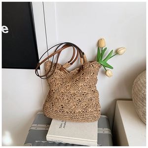 Detail of handmade straw bucket bag with hollow crochet texture and dual shoulder straps