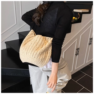Detailed view of beige handmade crochet bucket bag with intricate woven hollow pattern