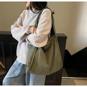 Close-up of green checkered canvas tote bag showing thick texture and spacious design