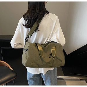 Rear view of model wearing olive green multi-purpose travel bag with wide nylon strap