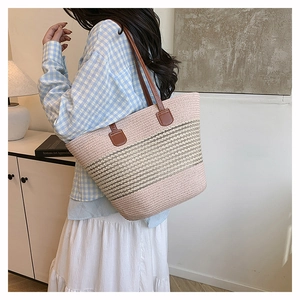 Dettaglio borsa tote intrecciata a righe rosa e kaki con spallacci in pelle marrone