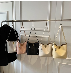 Detail showing five colors of leather bucket bags with gold locks and brand charms