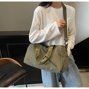 Crossbody view of army green nylon fitness bag with adjustable straps for gym and travel