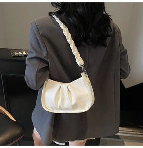 Detail of white pleated underarm bag with lychee texture leather and braided strap