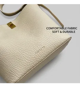 Close-up of beige leather bucket bag featuring pebble grain texture and gold turn-lock