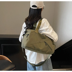 Detail of army green travel bag with crossbody strap and multi-pocket nylon design