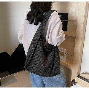 Detailed side view of the large capacity black and white checkered canvas tote bag