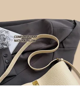 Detailed close-up of beige lychee texture leather shoulder bag with gold metal buckle