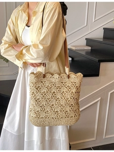 Handwoven straw tote bag with hollow flower crochet patterns and brown leather straps